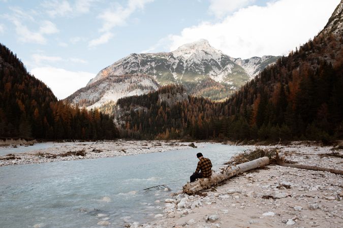 Man delighting in views near lake and mountains