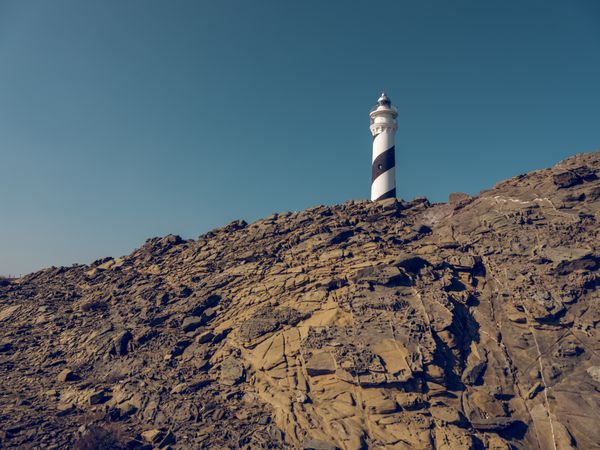 Lighthouse located on top of rocky hill