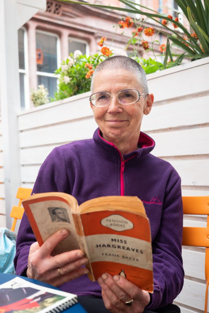 Older woman with short hair reading Miss Hargreaves