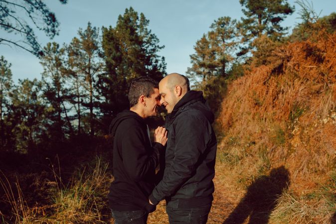 Men hugging and kissing in park