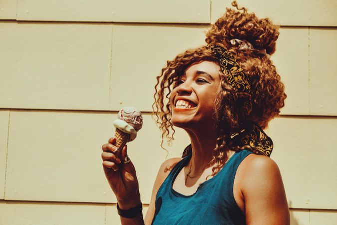 Smiling Black female enjoying an ice cream cone in the sun