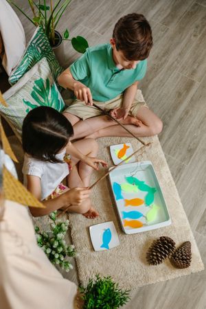 Children playing fishing game at home