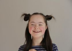 Portrait of female child smiling with stylish hairdo and looking away
