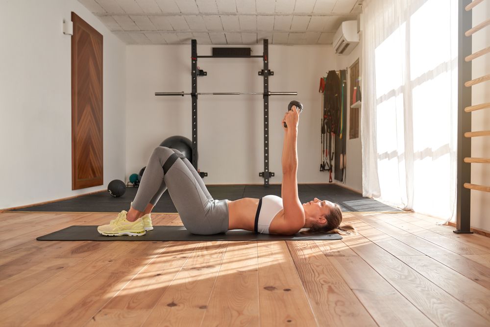 Determined sportswoman exercising in modern gym