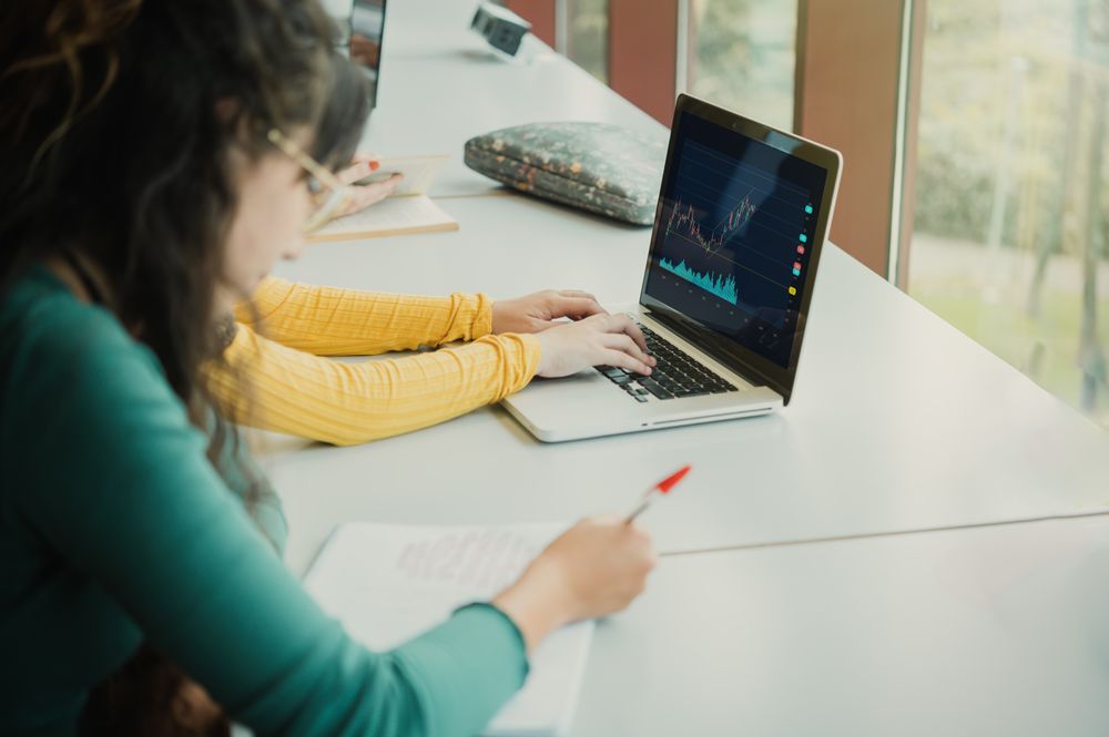 Woman writing in exercise book in university