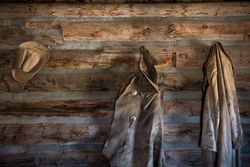 Coats and a cowboy hat at the "Hole-in-the-Wall" Cabin at Old Trail Town, Cody, Wyoming 4Bajd5
