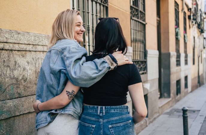 Lesbian couple hugging each other walking on street