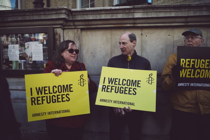 London, England, United Kingdom - March 19 2022: Man and woman with “I Welcome Refugees” signs