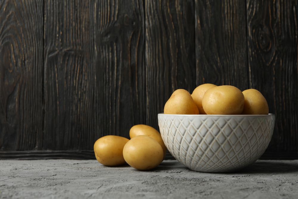 Side view of bowl of potatoes in dark kitchen