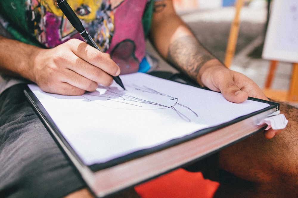 Cropped image of man drawing on a paper