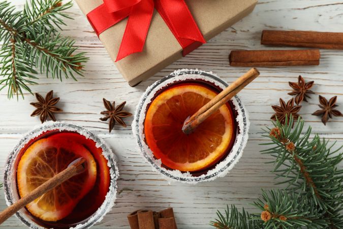 Glasses of tasty mulled and gift on wooden background, top view