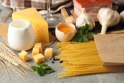 Composition with pasta and ingredients for cooking on gray background