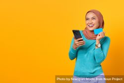 Muslim woman happy and holding credit card and smart phone beRpK0