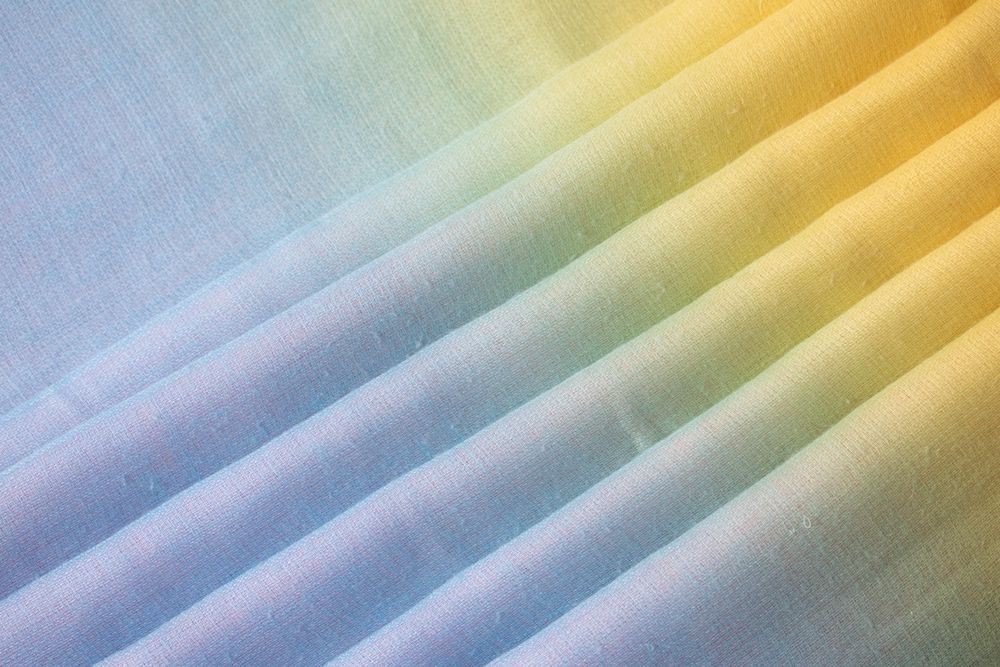Gradient colorful folded fabric background texture. blue yellow and green.