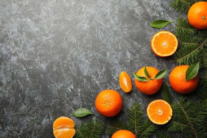 Mandarins and pine branches on gray smoky background