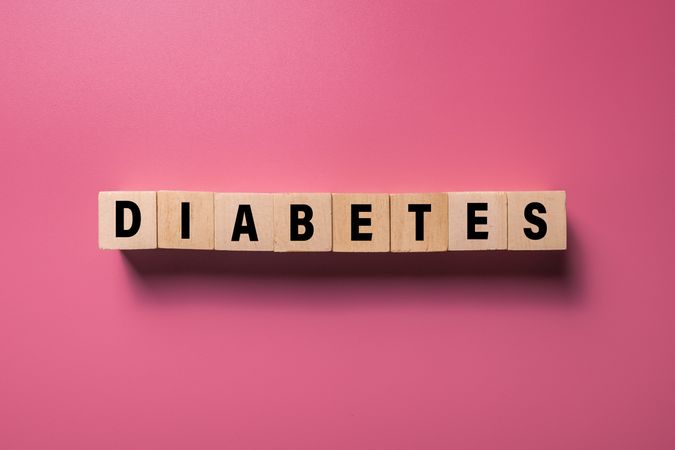 diabetes word on wooden blocks isolated on pink background