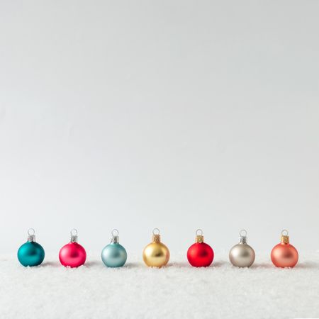Row of Christmas bauble decorations on snow