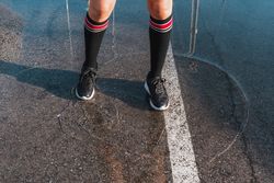 Woman in knee socks and shoes standing in puddles