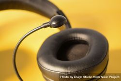 Single headphone ear speaker on yellow table 4mWR7v