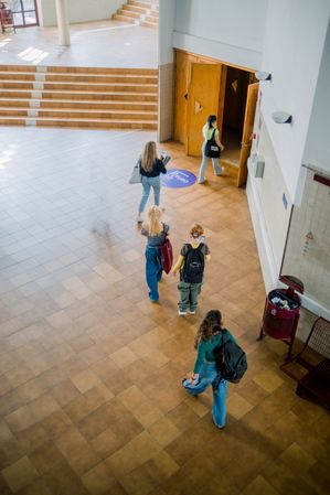 Unrecognizable students going to studies in hall