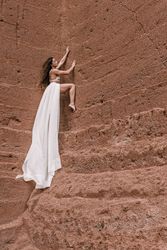 Elegant female posing on rocky cliff