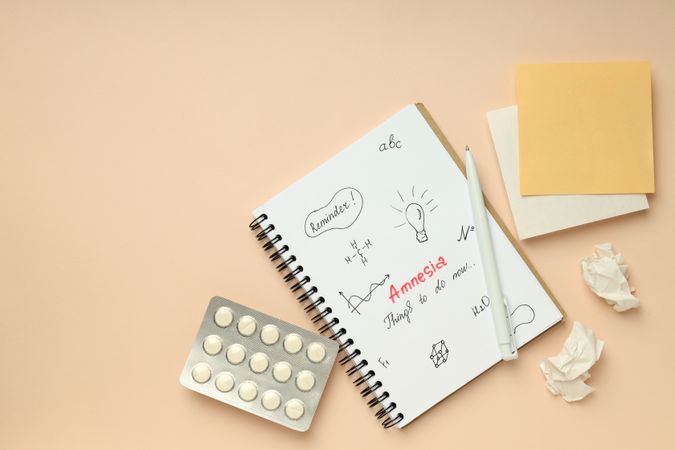 Flat lay of notebook with reminders for person with amnesia, copy space