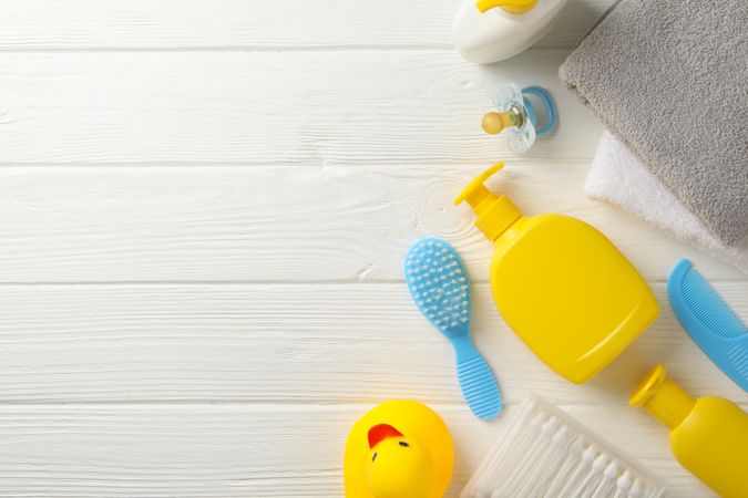 Baby hygiene accessories on wooden background, top view