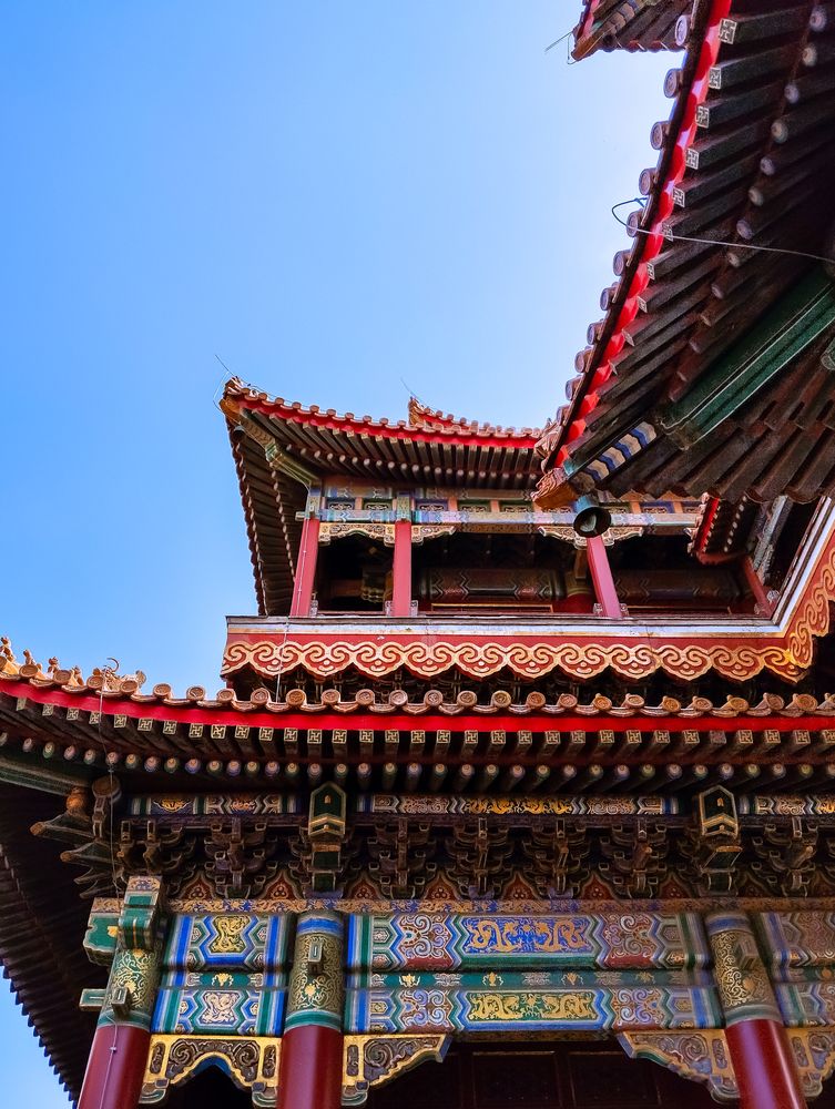A vibrant Chinese architectural temple with intricate red and gold details, ornate patterns