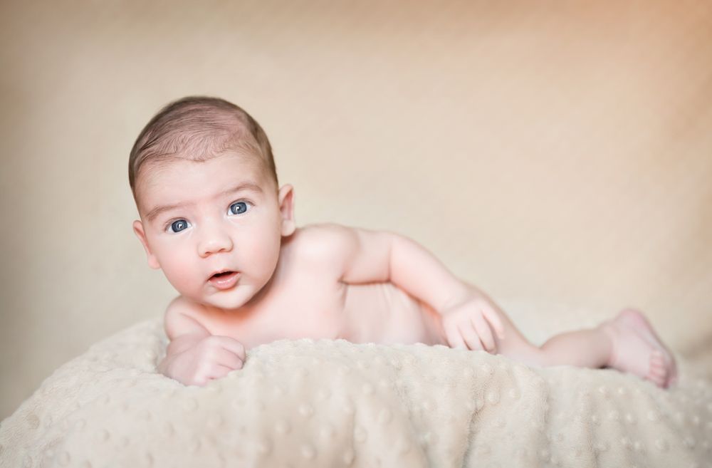 Portrait of newborn baby lying down over a blanket