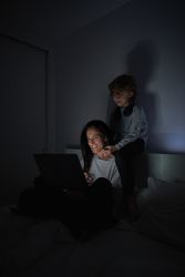 Mother and son surfing netbook in bedroom at night