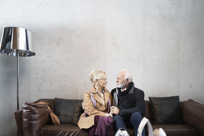 Mature couple sitting on leather sofa together