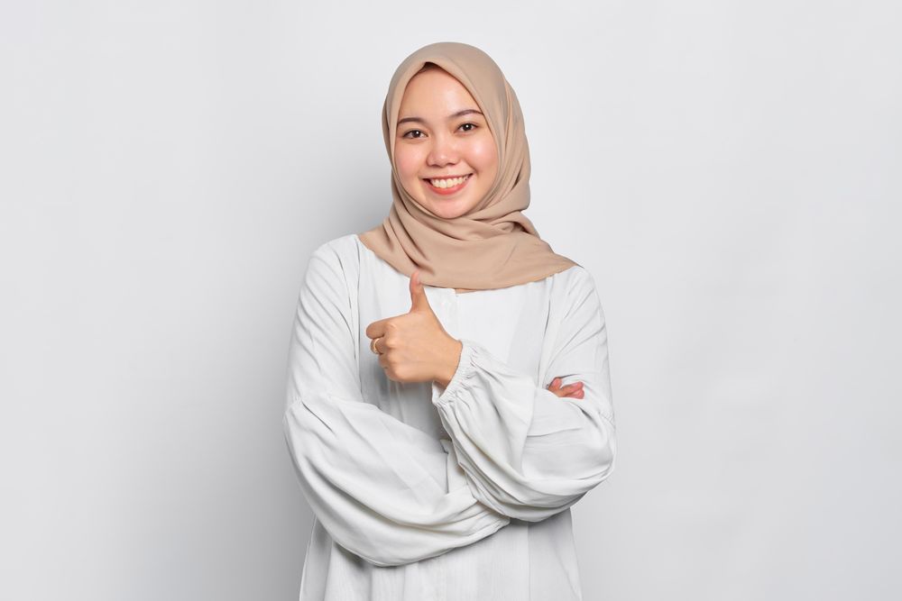 Asian female in headscarf with one thumb up