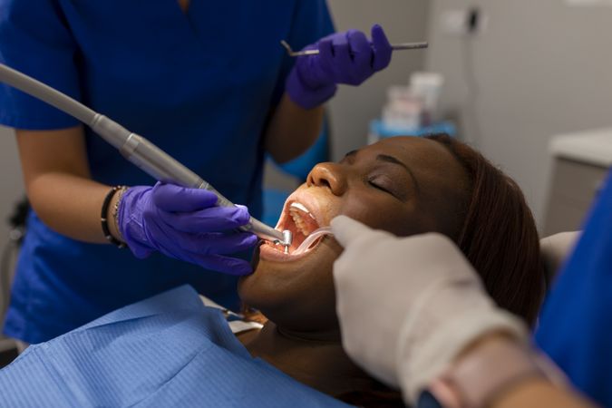 A Black woman patient in dental cleaning