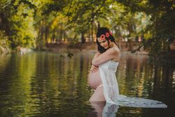 Pregnant woman standing in lake water