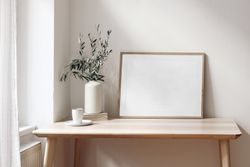 Empty horizontal wooden picture frame mockup with cup of coffee on wooden table