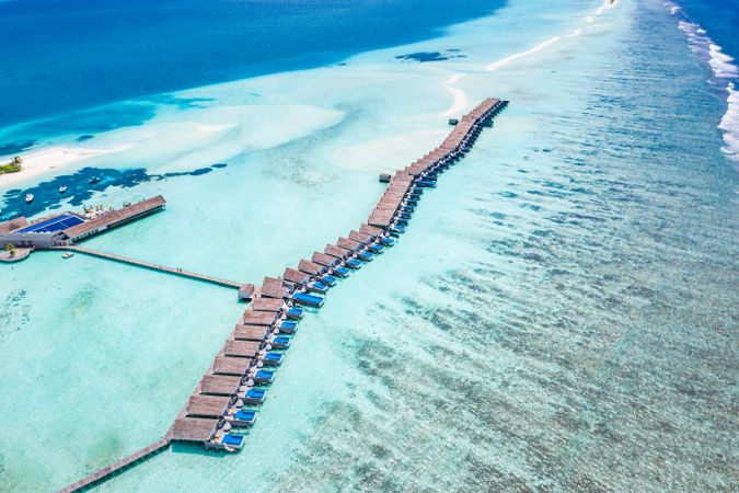 Overhead landscape shot of a row of overwater bungalows in the Maldives