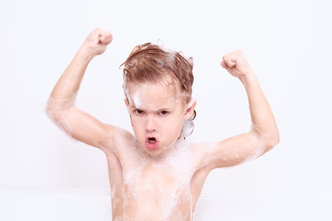 Boy showing biceps in bathroom