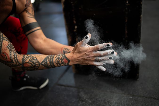 Female dusting hands before weightlifting