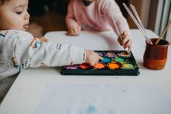 Side view of little boy touching paint palette