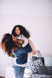 Mother lifting her smiling daughter