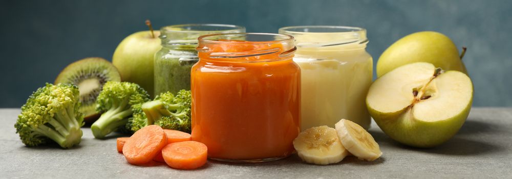 Composition with baby food on gray background, close up