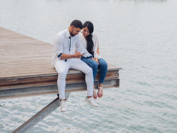 Woman with man using phone