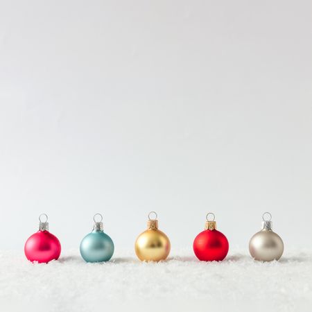Row of Christmas bauble decorations on snow