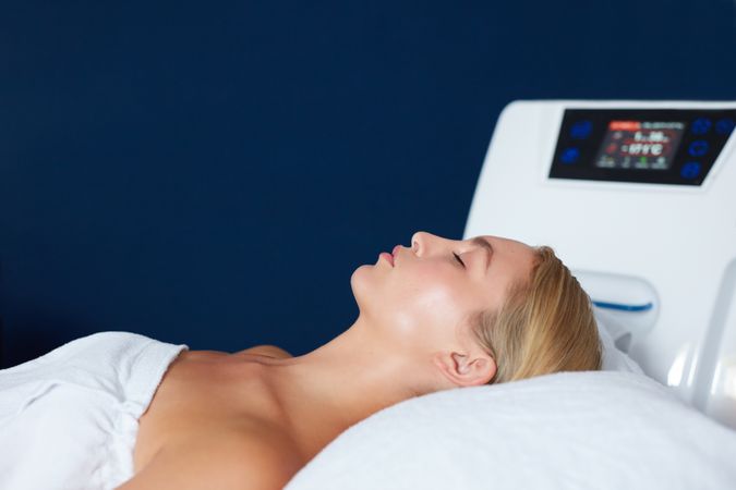 Side view of blonde woman lying back before facial treatment