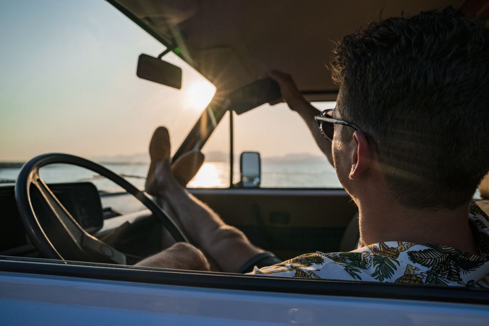 Happy adult man taking selfie with smartphone while sitting in van