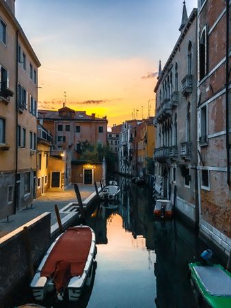 Water canal between buildings in Venice, Italy during sunset 