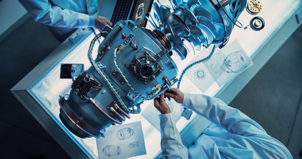 Top Down View of Two Engineers Discussing Work, Talking, Using Laptop Computer and Checking Blueprints