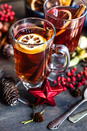 Dried orange slices and cinnamon sticks in mugs of warm drinks