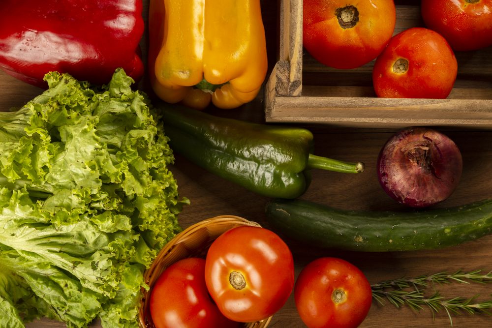 Top view of crate of fresh vegetables on wooden table