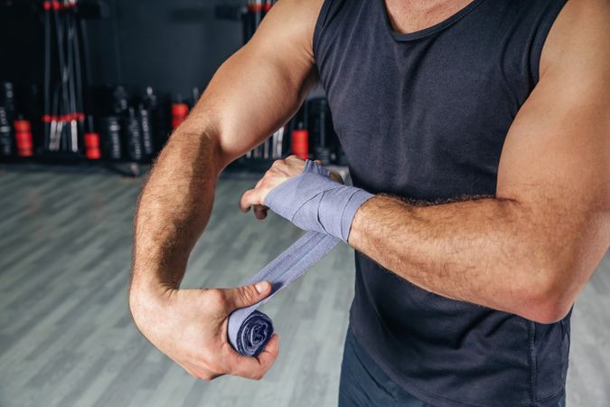 Man wrapping wrist in fitness class